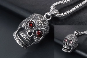 Macro view of gothic skull pendant with red gemstone eyes and intricate metal carving