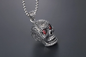 Detailed shot of retro punk skull pendant with red gemstone eyes and intricate engraving