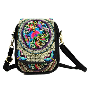 Ethnic style black canvas crossbody bag with vibrant floral embroidery and gold metal clasp