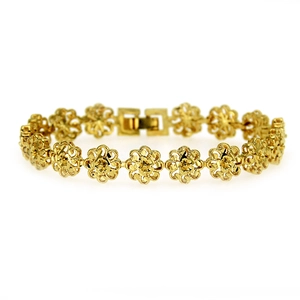 Macro shot of gold hollow flower bracelet links showing intricate floral metalwork