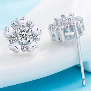 Macro shot of a floral silver earring featuring a central white diamond and petal accents