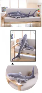Detail of shark plush toys in various sizes arranged on a sofa as soft home decor