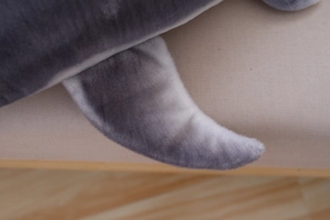 Macro shot of soft plush fabric and neat stitching on a purple long shark body pillow