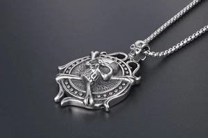 Macro shot of a silver vintage punk skull and crossbones steering wheel necklace pendant