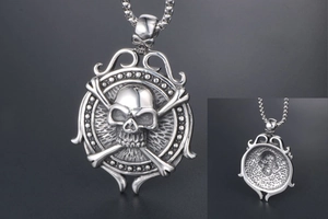 Macro detail of vintage punk silver skull pendant with rudder and flame texture details