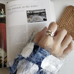 Detailed view of silver knot ring showing woven structure on an open ring band