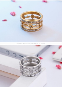 Detail of gold and silver stainless steel rings with star patterns and white zircons