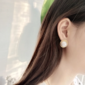 Close-up of a vintage 925 silver gold pearl stud earring worn on a model ear