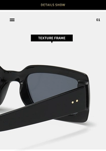 Detail shot of black rectangular sunglasses frame featuring gold rivet accents