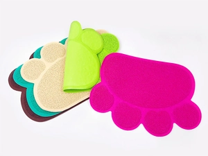 Close-up of colorful paw-shaped PVC cat litter mats showing non-slip textured mesh material