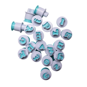 Macro shot of purple alphabet and number cookie plunger cutters for fondant cake decorating