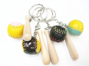 Detailed shot of mini wooden baseball bat and multi-colored leather ball keychains