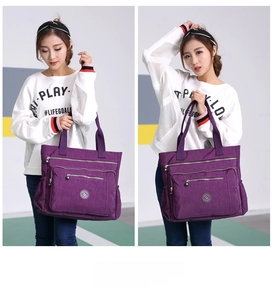 Detailed view of purple nylon tote bag featuring multi-pocket design and zip compartments