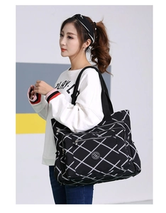 Close-up of quilted nylon shoulder bag with zipper pocket and round logo detail