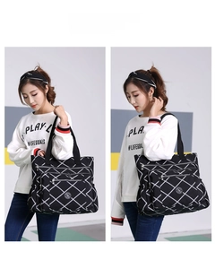 Detail view of large capacity black nylon tote bag with white diamond lattice pattern
