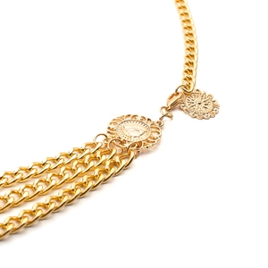 Detail of vintage gold layered body chain featuring sunflower carved metal discs