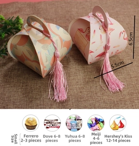 Detail of small wedding candy gift boxes with peach and flamingo patterns and pink tassels