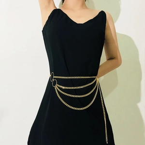 Detail of layered gold body chain featuring decorative large metal rings on a black dress