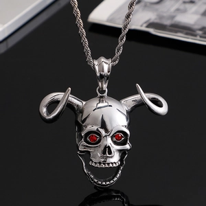 Silver skull pendant necklace with curved horns and red gemstone eyes on black background