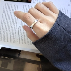Close-up of minimalist S925 sterling silver interlocking cross ring on model's hand