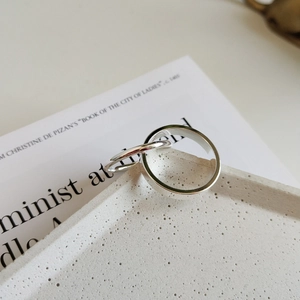Detail of minimalist S925 sterling silver interlocking double band rings on stone