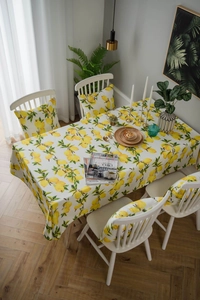Detail of fresh lemon print tablecloth and matching chair cushion in cotton linen fabric
