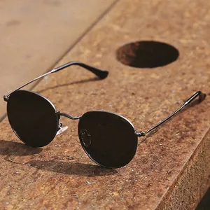 Retro polarized round sunglasses with black metal frames on industrial rusty metal background