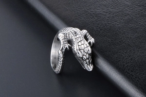Macro view showing the detailed crocodile skin texture on a polished silver steel ring