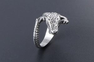 Macro side view of crocodile-shaped steel ring with detailed scales and head engraving