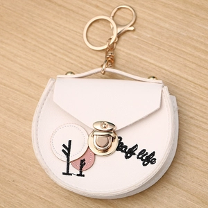 Detail of cream leather coin purse with tree embroidery and gold lobster clasp