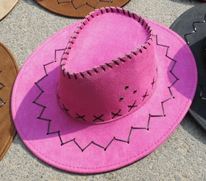 Detail of pink suede cowboy hat with black decorative stitching and metal eyelets