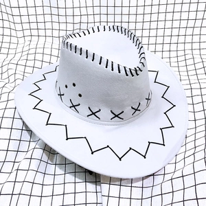 Detailed view of a white cowboy hat with black decorative hand-stitching on the wide brim