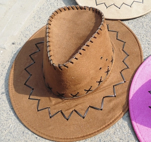 Detailed view of western cowboy hat featuring bold black cross-stitch and metal air vents