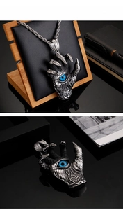 Macro detail of gothic devil hand pendant with realistic blue eye and steel texture