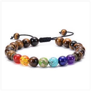 Macro detail of braided tiger eye and chakra stone yoga bracelet with adjustable black cord