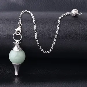 Natural light green crystal sphere pendulum with silver chain on black leather background