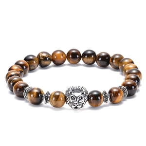 Macro shot of tiger eye stone beads featuring a silver lion head charm detail