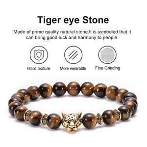 Natural tiger eye stone beaded bracelet with golden leopard head charm on white background