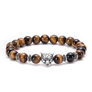 Macro detail of natural brown tiger eye beads with silver leopard head and spacer beads