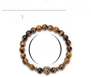 Detail of 8mm tiger eye stone beads bracelet with a golden lion head and metal spacers