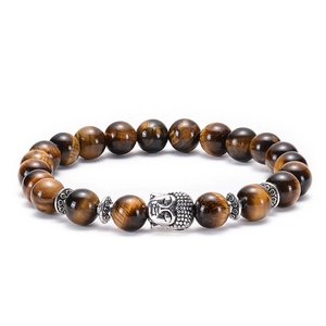 Detailed close-up of natural tiger eye stone beads and silver Buddha head on the bracelet