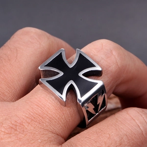 Macro detail of men's stainless steel cross ring with black enamel finish on finger
