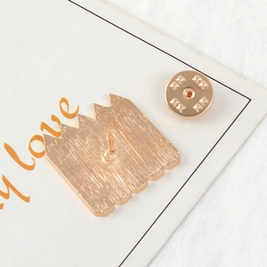 Macro shot of the gold alloy brooch back showing the metal pin, fastener and brushed texture