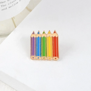 Colorful rainbow pencil enamel pin brooch with gold plating on a white surface