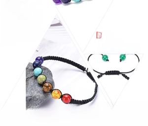 Detail view of seven chakra energy stone beads on a black braided adjustable cord bracelet