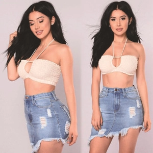 Detail of blue distressed denim mini skirt with ripped holes and raw hem design