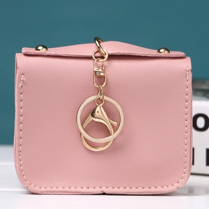 Pink cartoon owl coin purse with gold hardware and snap closure on a white surface