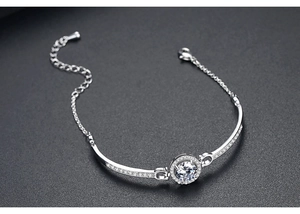 Detailed macro view of silver-toned bracelet with pavé cubic zirconia round charm