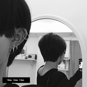 Three sizes of silver titanium steel hoop earrings showing stylish layered wearing effect