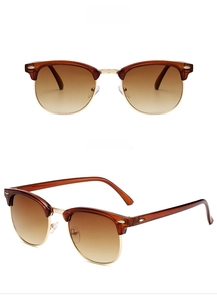 Detail view of semi-rimless Clubmaster sunglasses in brown and gold with gradient lenses